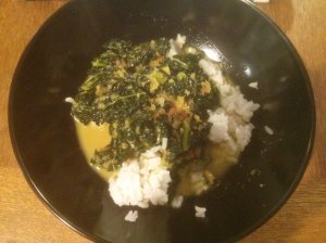 Yellow coconut curry in a bowl with kale and rice
